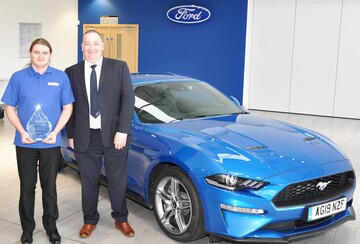 James Stuart receives his award from a representative from Ford