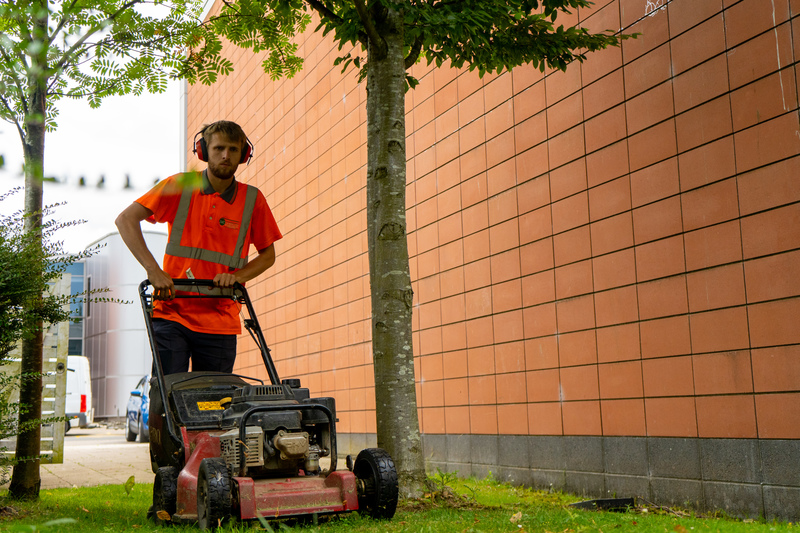 A member of the JMC team mowing the grass at Pioneer Court