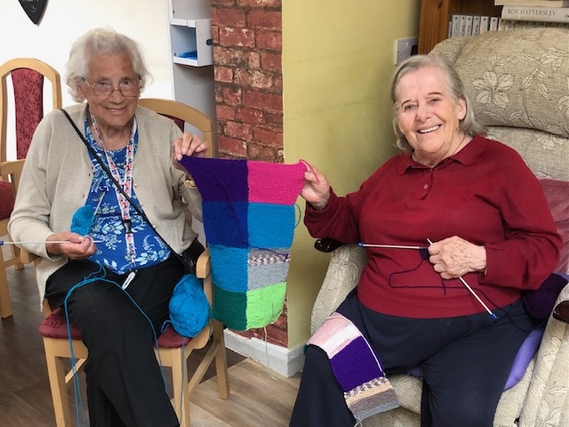 Residents with one of the blankets they've made