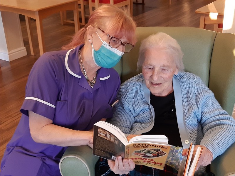 A carer and resident sharing a memory book