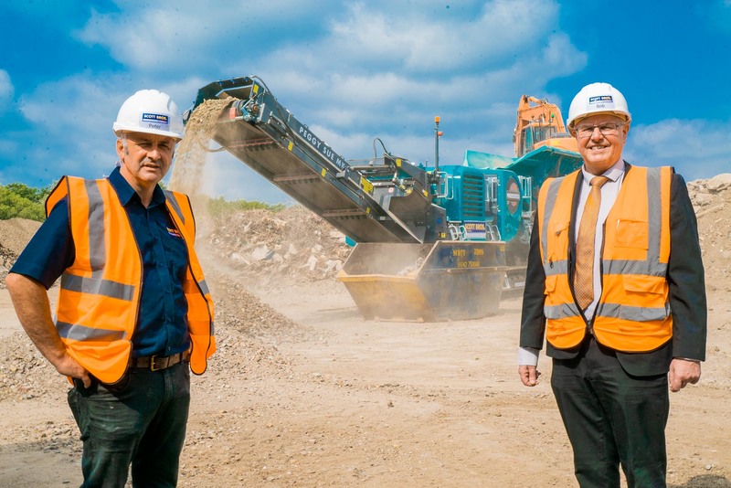 L-R: Scott Bros directors Peter Scott and Bob Borthwick pictured with a new £300,000 crushing machine bought last year to boost production of recycled aggregates