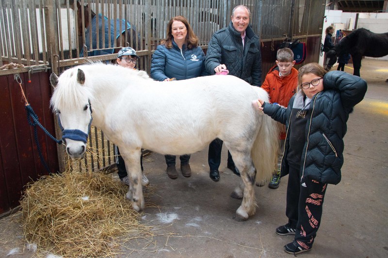 Paula Allen, Bill Scott OBE with two children enjoying equestrian care