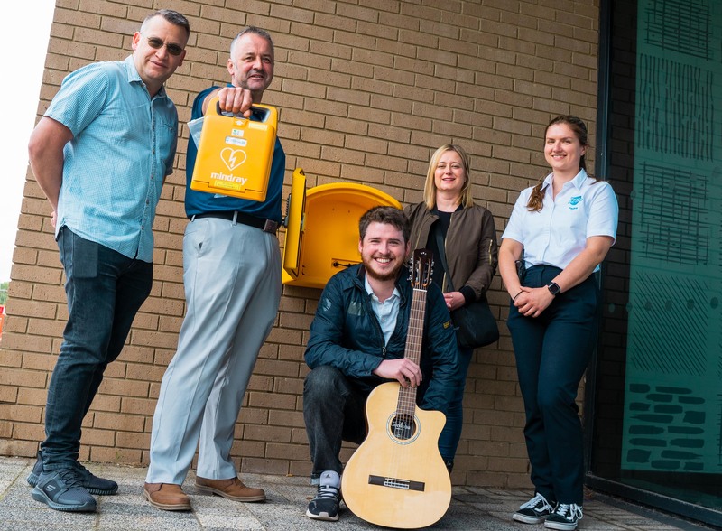 L-R Electrical engineer Chris Burnett, who installs the defibrillators free of charge, Peter Scott, musician Tom Powell, Deborah Gale, and Paulina Banaszek of IB Leisure with the public access defibrillator recently installed outside the health and fitnes
