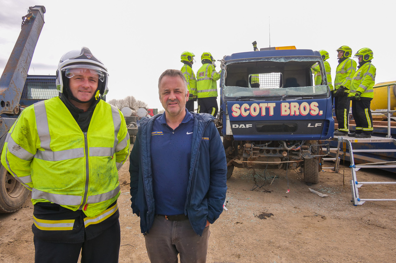 (L-R) Watch manager David Barkley with Peter Scott as firefighters practice rescue techniques on a donated Scott Bros truck