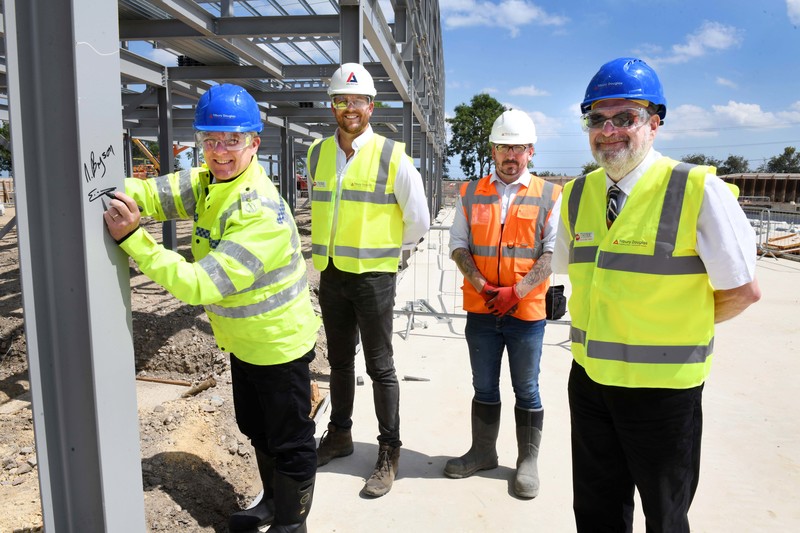  L-R: Deputy Chief Constable Ciaron Irvine signs the steel frame watched by Arlington Real Estate’s Dean Cook, Eddie Wooton, Tilbury Douglas Project Manager, and Deputy Police and Crime Commissioner Nigel Bryson