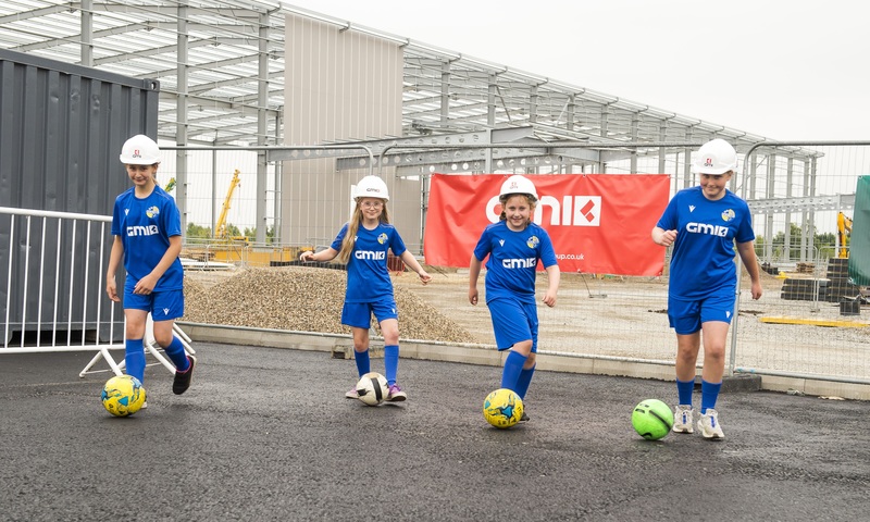 Brayton Belles’ Vivienne Foulger, Ellie Cooper, Sophie Ball, and Lyla Cooper visit one of their sponsor’s construction sites to unveil their new GMI-branded kit