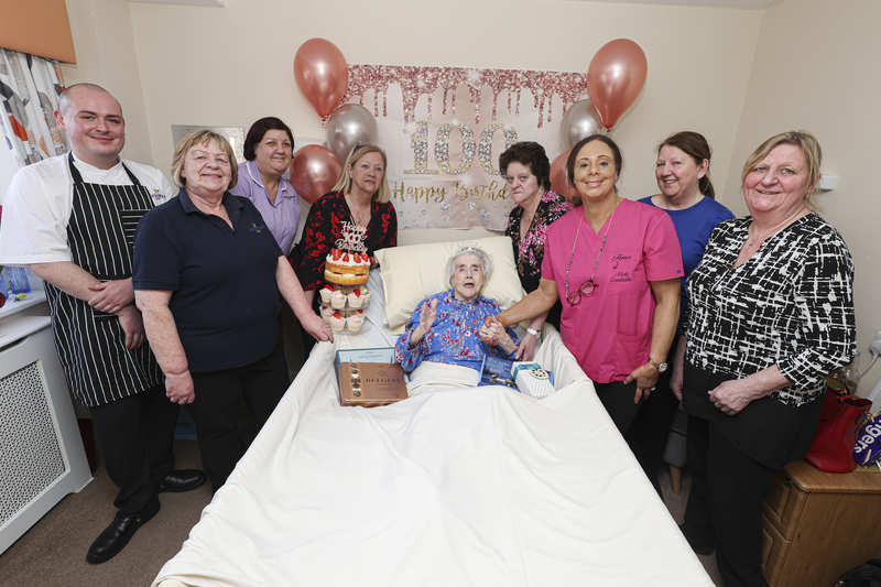 Hilda surrounded by her family and care home staff