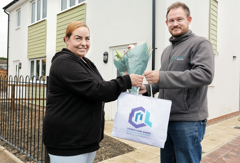 Beyond Housing Housing Officer Christopher Brown (right) hands some flowers and a goody bag to new customer Katie Micklewright who has just moved into her newly completed home