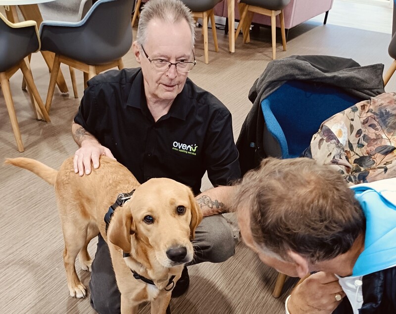 Ovenu managing director Rik Hellewell (centre) meets trainee Guide Dogs pup Ralph for the first time