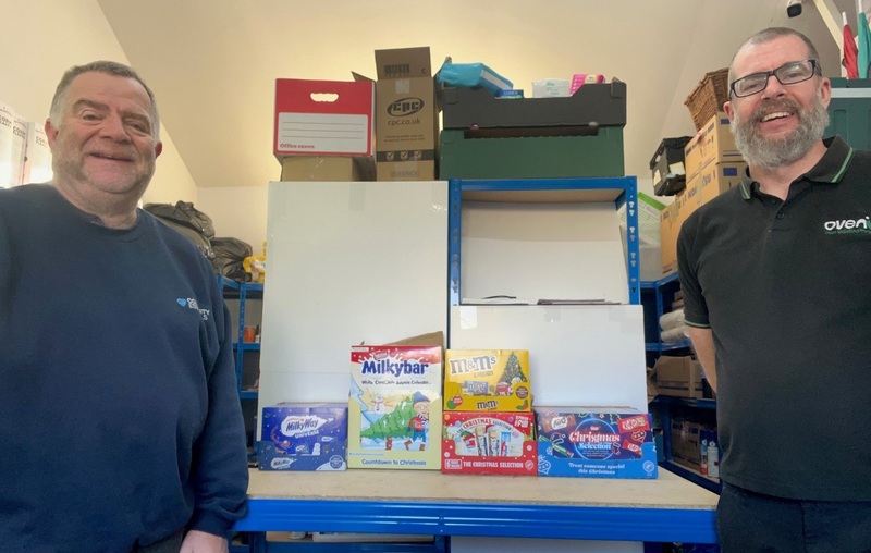 Community Essentials volunteer Kevin Palmer (left) and Elliott Robinson of Ovenu Solihull, with some of the donated selection boxes and chocolate advent calendars