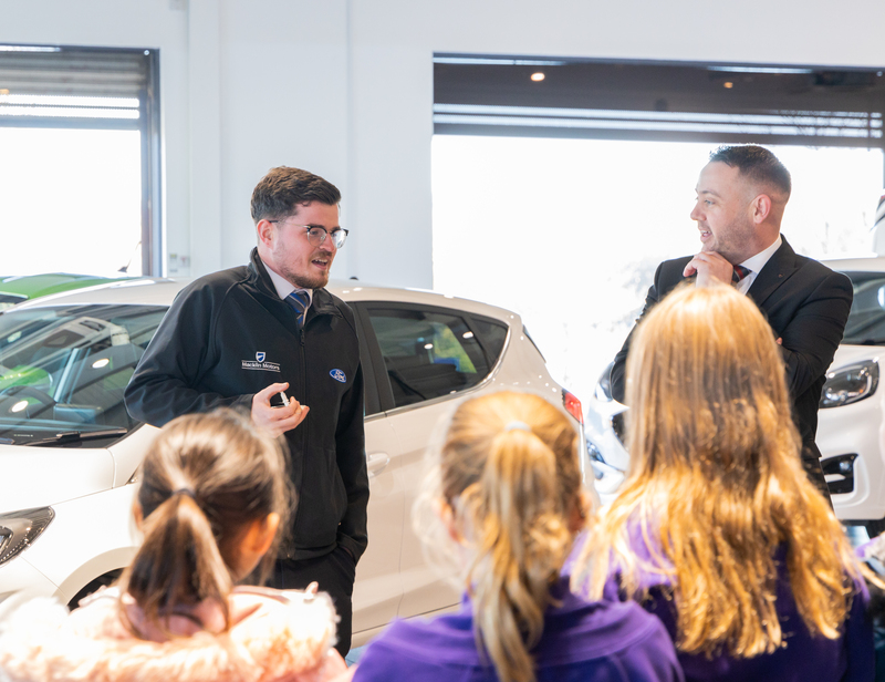 Sam Bannister Senior Sales Executive and Mark Super General Manager talking to the children 