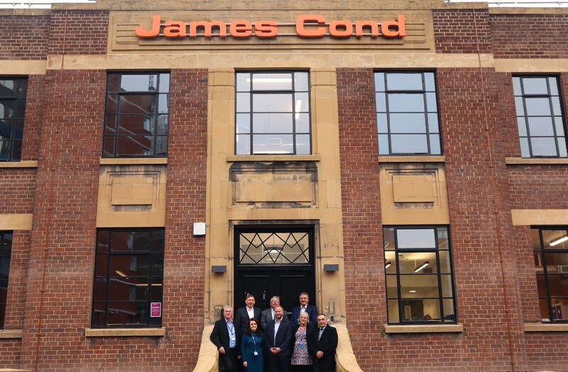 Some of the key stakeholders gather outside the art deco James Cond building following its transformation