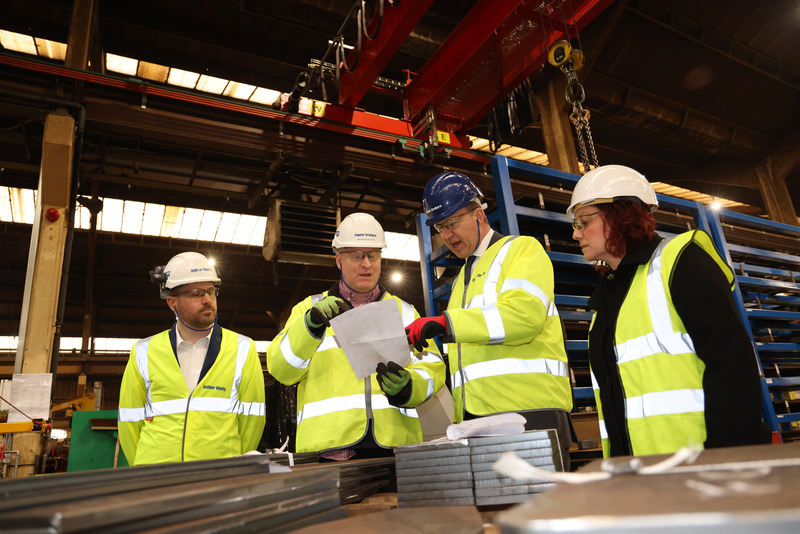 Jesse Norman (centre right) engaging with staff during a tour of the facility.  